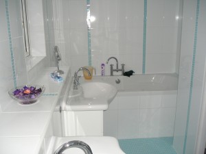 En-suite bath and shower room in white and glass mosaic tiles